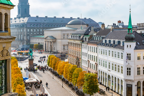 Jesienią w Kopenhadze ludzie chodzą po placu w pobliżu fontanny bociana, robią selfie w restauracji, panoramiczny widok na miasto