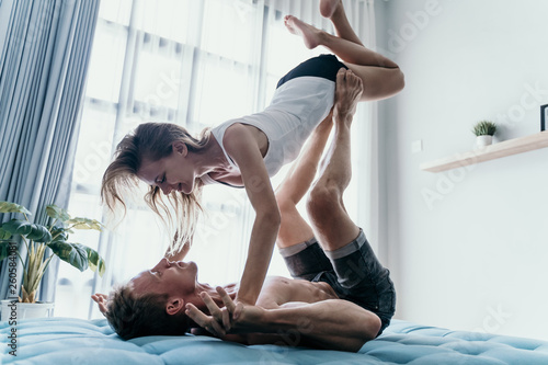 Happy young couple carrying and lift girl by his feet upside down