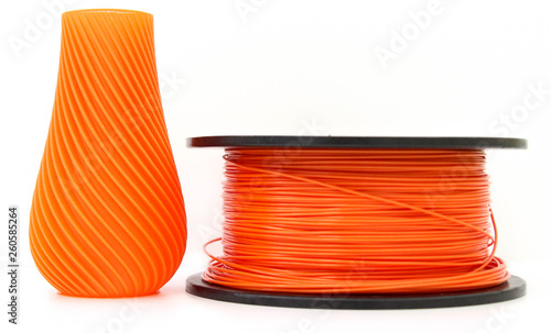 Orange vase and filament for 3d printing, isolated on white background, produced from pla, horizontal view, macro