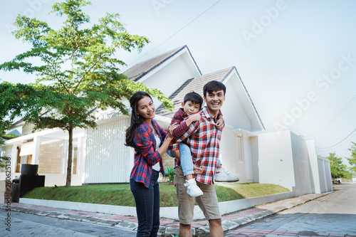 father piggyback ride with his son in front of the house playing enjoying their time in the morning