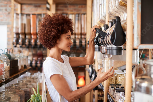 Woman Buying Cereals And Grains In Sustainable Plastic Free Grocery Store