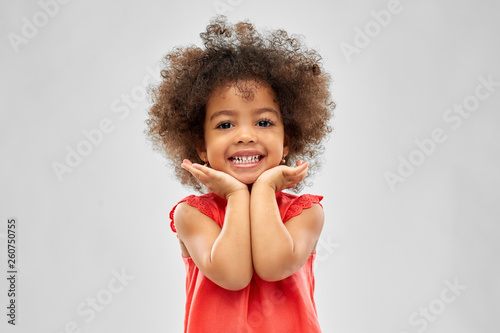 childhood and people concept - happy little african american girl over grey background