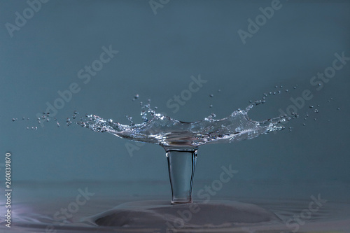 Tropfenfotografie - Schirm auf Wassersäule vor hellblauem Hintergrund