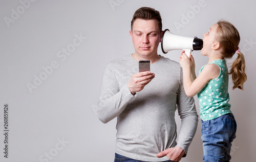 Father using smartphone ignoring his daughter