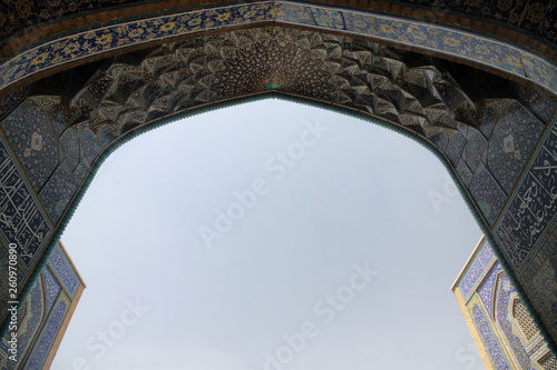 niebieska mozaika zdobiąca sklepienie łuku przy wyjsciu z zabytkowego meczetu w iranie i niebieskie niebo w tle