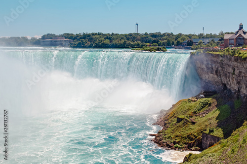 Aerial top landscape view of Niagara Falls between United States of America and Canada. Horseshoe of Canadian waterfall on sunny day. Water tour boat at famous tourist landmark