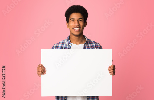 Happy guy showing blank placard with copy space for your text