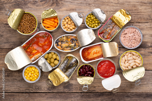 Canned food on wooden background, top view 