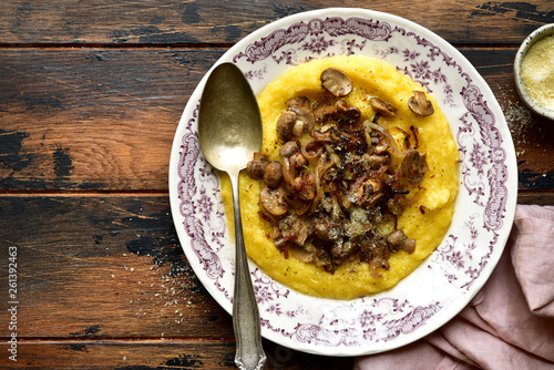 Polenta with fried mushrooms, parmesan cheese and caramelized onion.Top view with copy space.