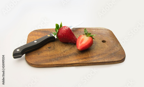 Truskawki na desce do krojenia z nożem