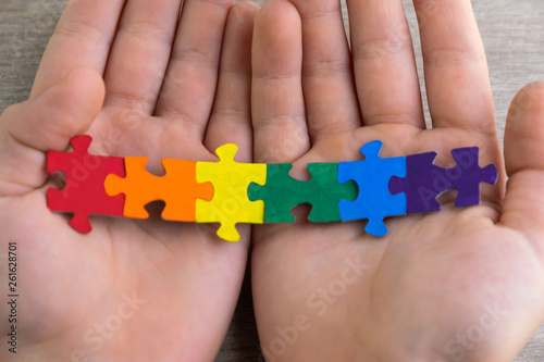 teaching sexual tolerance in school and at home: a boy builds an LGBT flag using puzzles