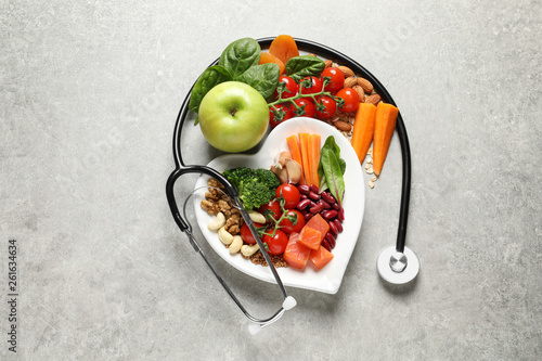 Flat lay composition with plate of products for heart-healthy diet on grey background