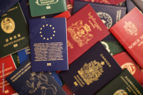 Blue biometric passport of the European Union on a blurred background of mixed passports from around the world