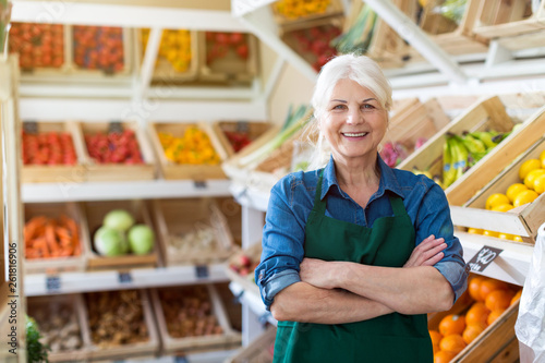 Portrait of confident owner with arms crossed standing in small grocery store