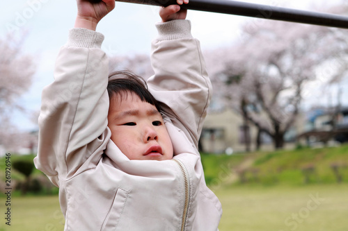 鉄棒にぶら下がる子供