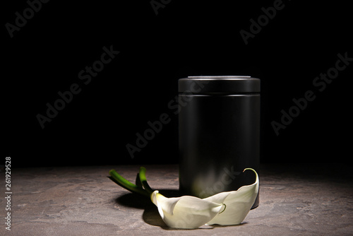 Mortuary urn and flowers on dark background