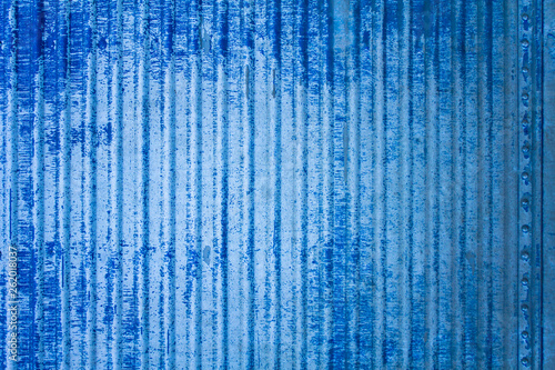 old white blue battered metal fence wall with damages and rivets. vertical lines. rough surface texture