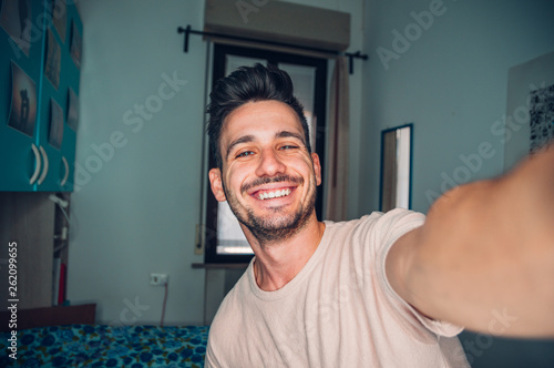 Handsome caucasian man taking a self portrait indoor at home