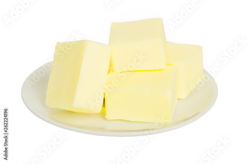 Close-up of fresh butter pieces on a white plate. Plate with butter isolated on white background. Sandwich butter. Natural fat nutrient.