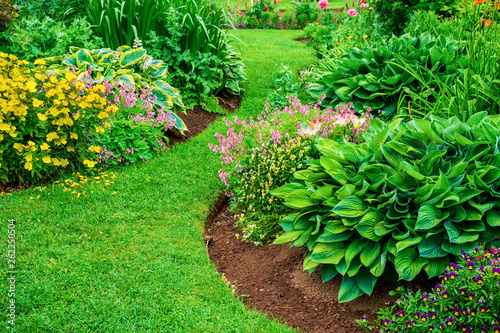 Perennial flower beds with lilies, hosta and bleeding hearts.