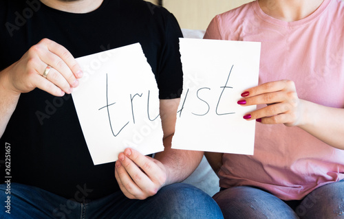 No trust. Cheating, infidelity, marital problems, having an affair and another partner, betrayal, mistrust or being unfaithful concept. Couple, man and woman, ripping same paper. 