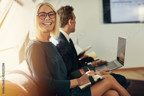 Smiling businesswoman writing in an organizer during an office p