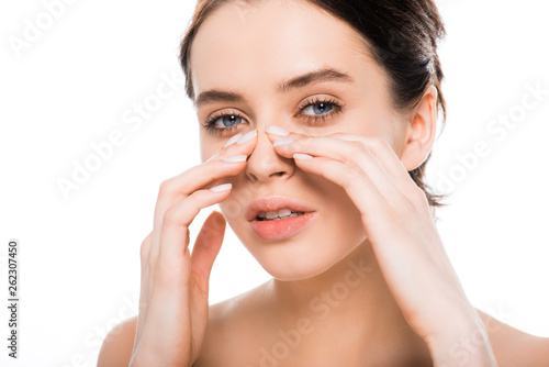 beautiful nude woman touching nose after rhinoplasty and looking at camera isolated on white