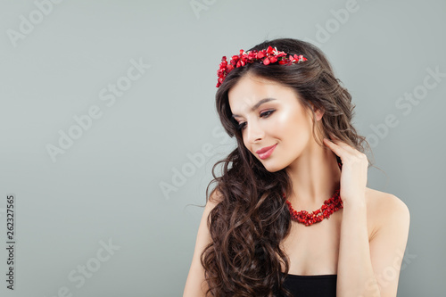 Nice model woman with long brown hair and coral jewelry