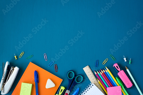 School supplies on blue background. Top view. Copy space.