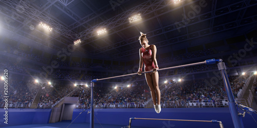 Female athlete doing a complicated exciting trick on horizontal gymnastics bars in a professional gym. Girl perform stunt in bright sports clothes