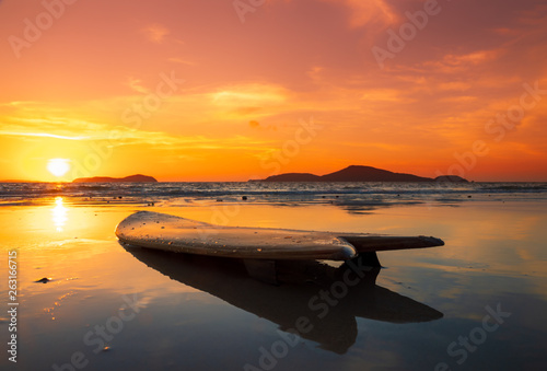 surfboard on the beach in sea shore at sunset time