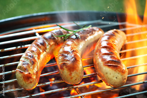 Delicious sausages sizzling over the coals on barbecue grill