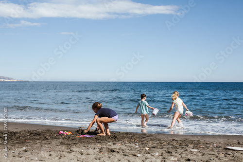  three children playing in the sand on the beach