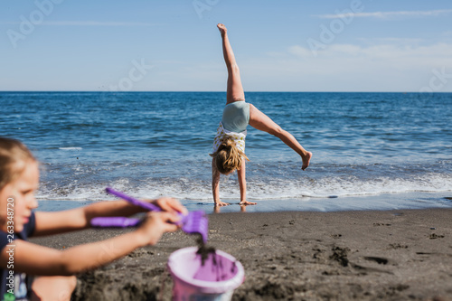 Kids playing on the beach happy doing pirouettes