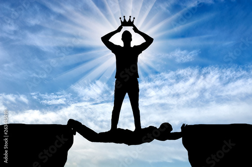 Selfish man puts his crown on his head, he is on the man in the form of a bridge over the abyss