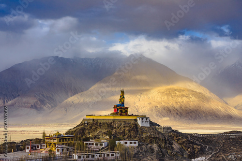 The Maitreya Buddha statue with Himalaya mountains in the background from Diskit Monastery or Diskit Gompa, Nubra valley, Leh Ladakh, Northen India.
