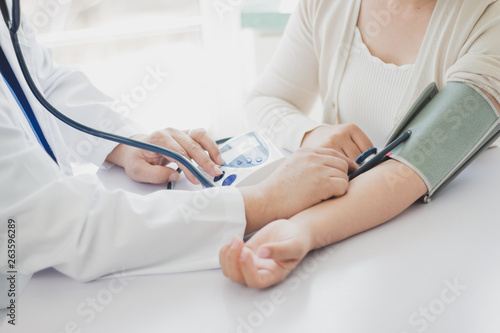 The doctor measures blood pressure to the patient