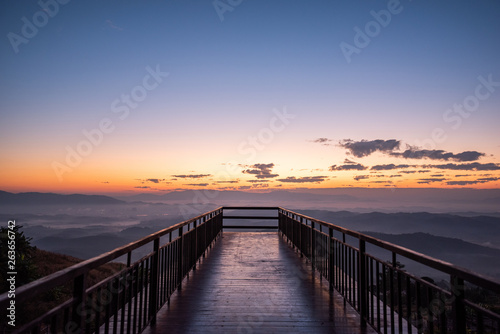rising sun in the morning on top of the hill with wooden pathway ahead to sunrise.Success concept