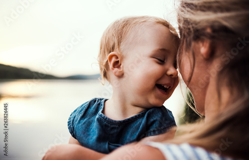 Smiling mother holding toddler outdoors