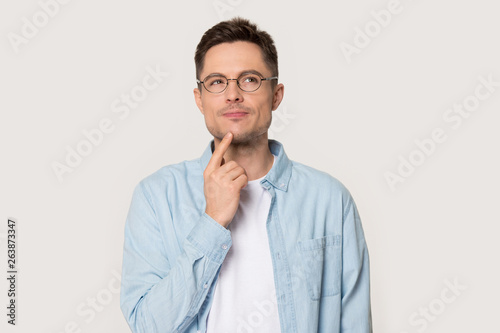 Thoughtful man in glasses isolated on grey background thinking