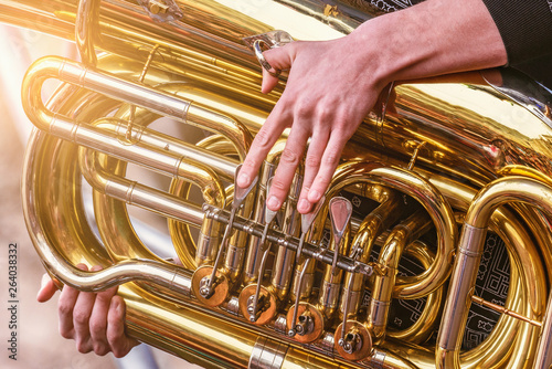 Musician playing tuba at evening time on the city square.