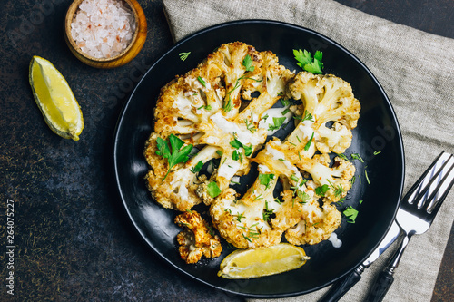 Fried cauliflower steak with greens and spices.