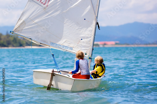 Child sailing. Kid learning to sail on sea yacht.