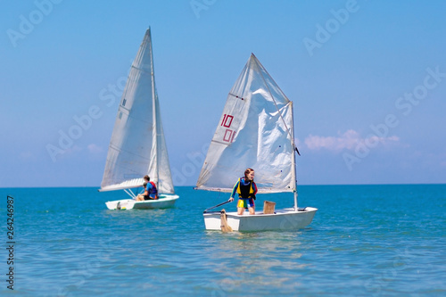 Child sailing. Kid learning to sail on sea yacht.