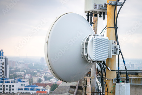 Outdoor mobile antenna is on the roof. The base station repeater is installed at the top of the building. Wireless telephone transmitter is a close up.