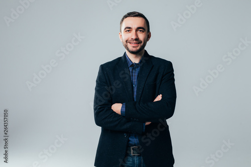 Smiling businessman standing with arms folded isolated on a white background