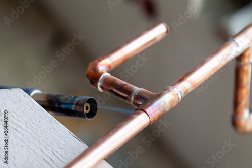 Closeup professional soldering copper pipes gas burner. Concept installation, plumbing replacement, solder flux paste, pipeline repair, professional master, pipe leakage