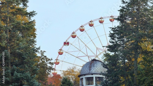 Ferris wheel rotates in a park in the foreground roof observatory