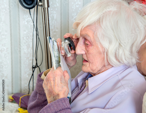 Visually impaired elderly woman with magnifyer