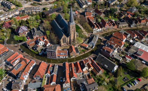 Aerial historic dutch village Maasland with central church and canal curving around